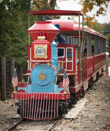 Red and blue train with a team member operating the train